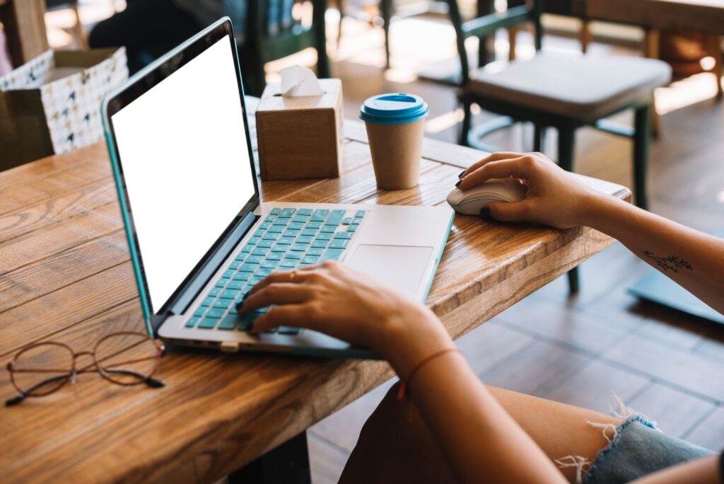 Close up of woman browsing on the laptop in the cafe